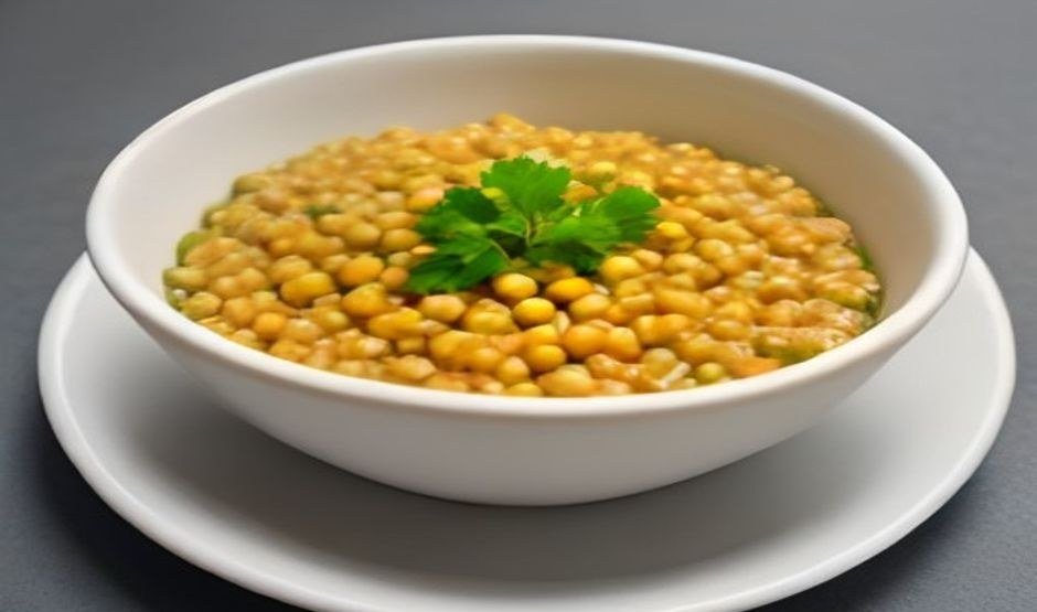 A bowl of lentils, tofu and quinoa with fresh herbs on a light table