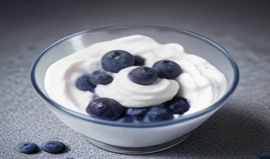 Plain yogurt topped with fresh blueberries in a glass bowl, a gentle food to break a fast
